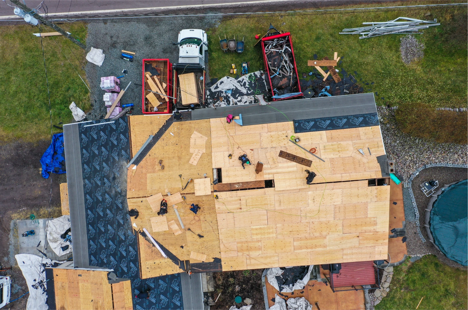 Roof tear-off and replacement in progress with exposed decking